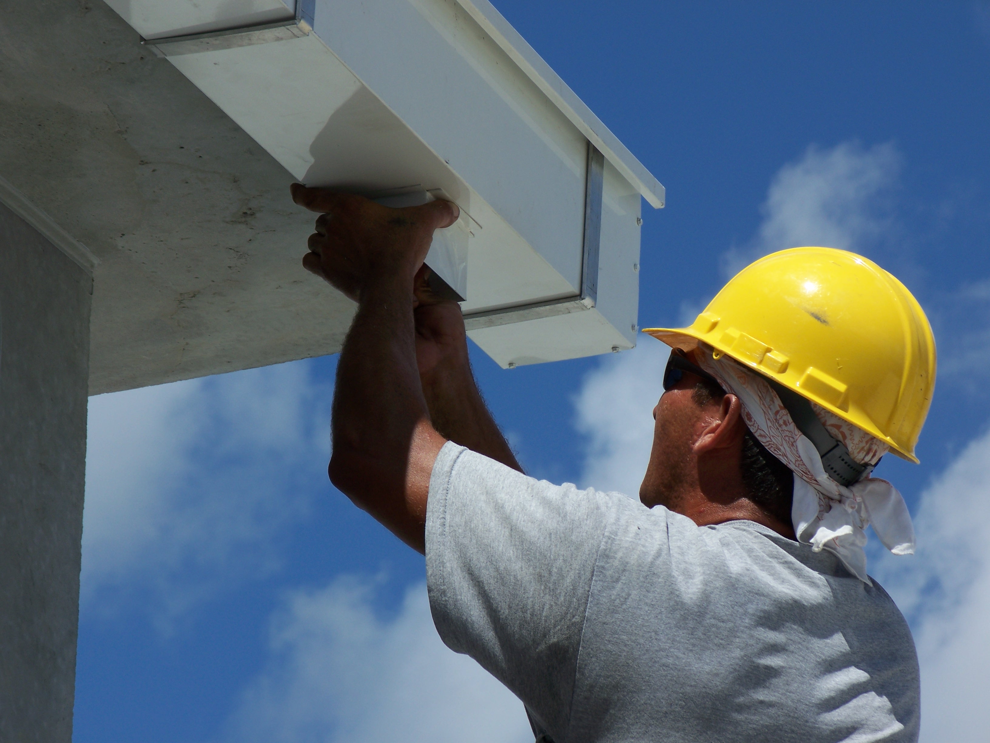 Handwerker bei der Montage einer Kastenrinne an einem Gebäude
